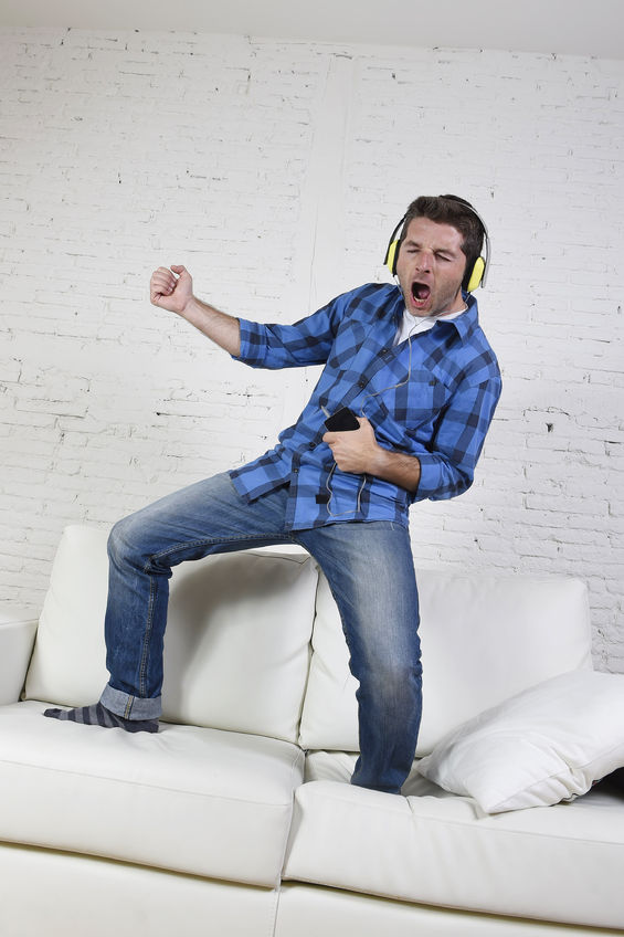 a man dancing while listening to music in the couch