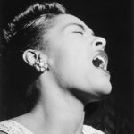 a woman singing while closing her eyes