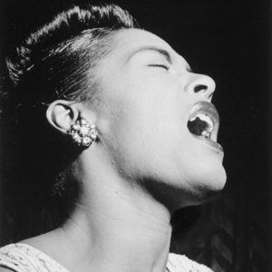 a woman singing while closing her eyes